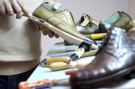 Bilde av hender som arbeider med en sko